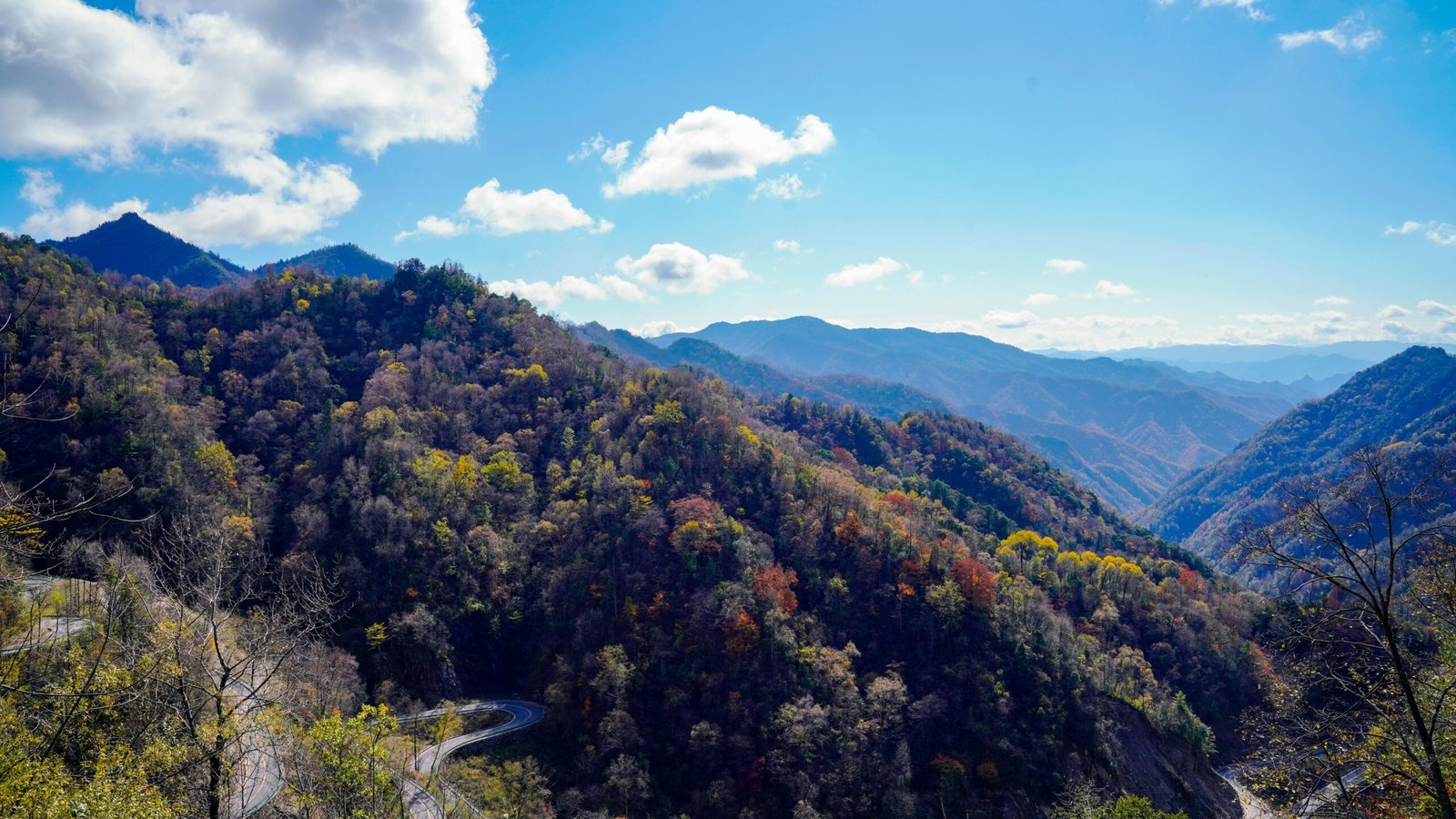 a scenic view of a winding road in the mountains